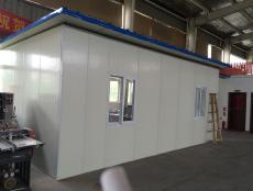 Small grey-white internal enclosure inside a steel workshop