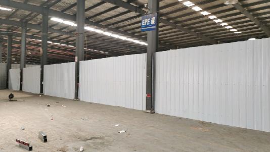Wide view of grey-white internal wall panels inside a steel workshop