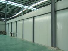 Grey-white internal wall panel system inside a steel workshop