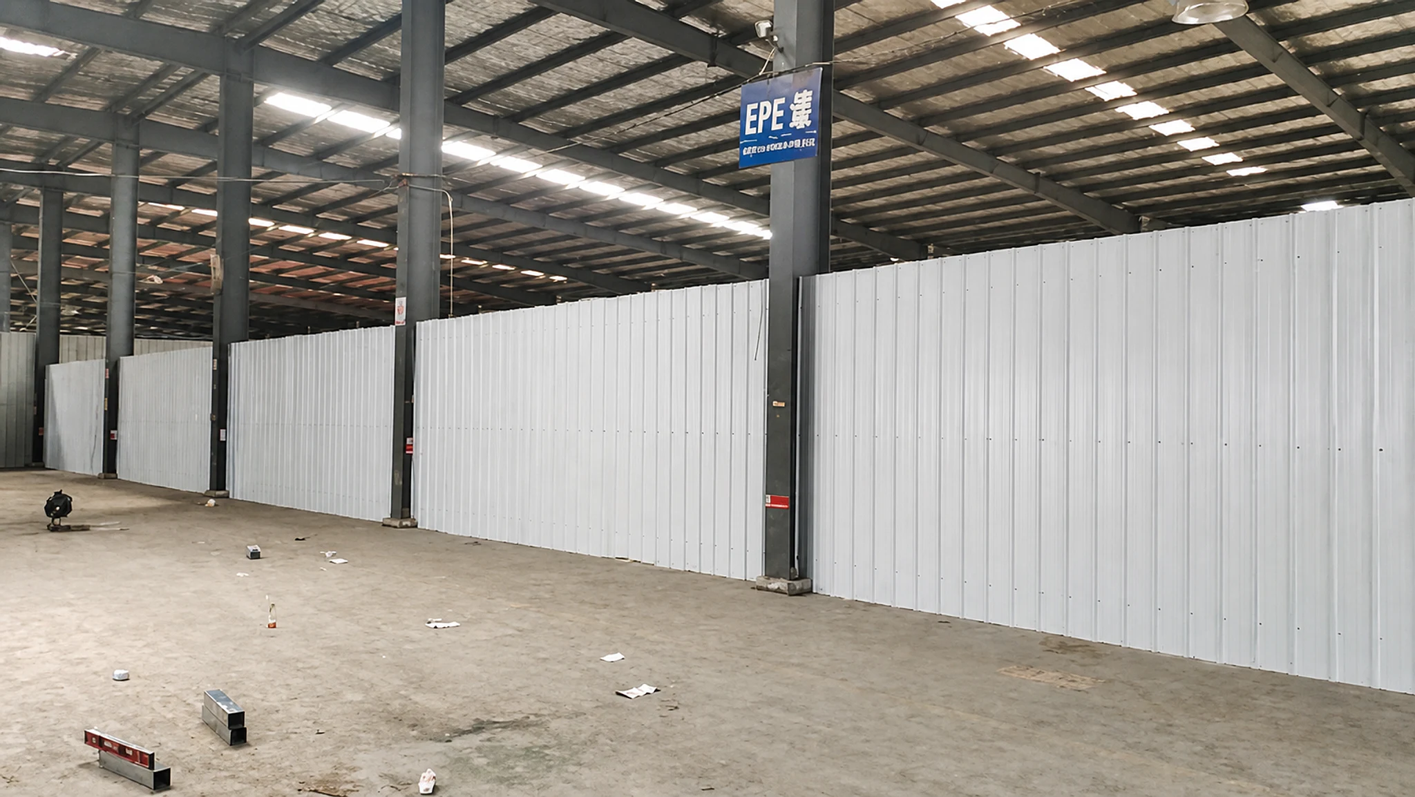 Grey-white internal wall panels inside a steel workshop