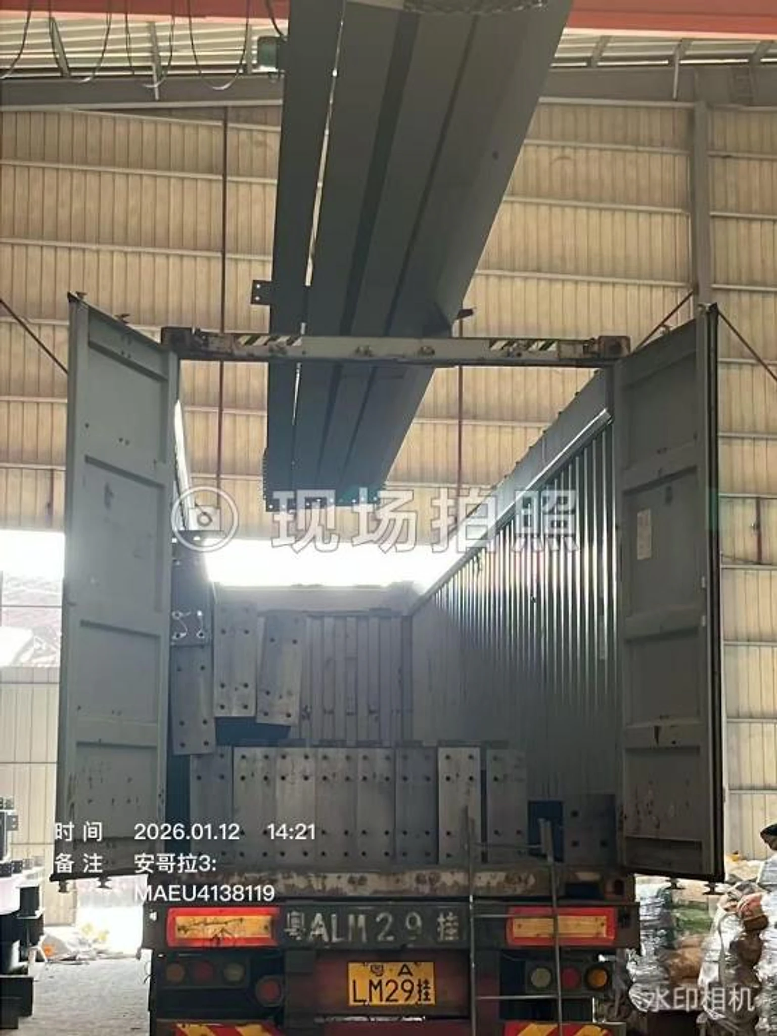Long steel members entering an open-top container