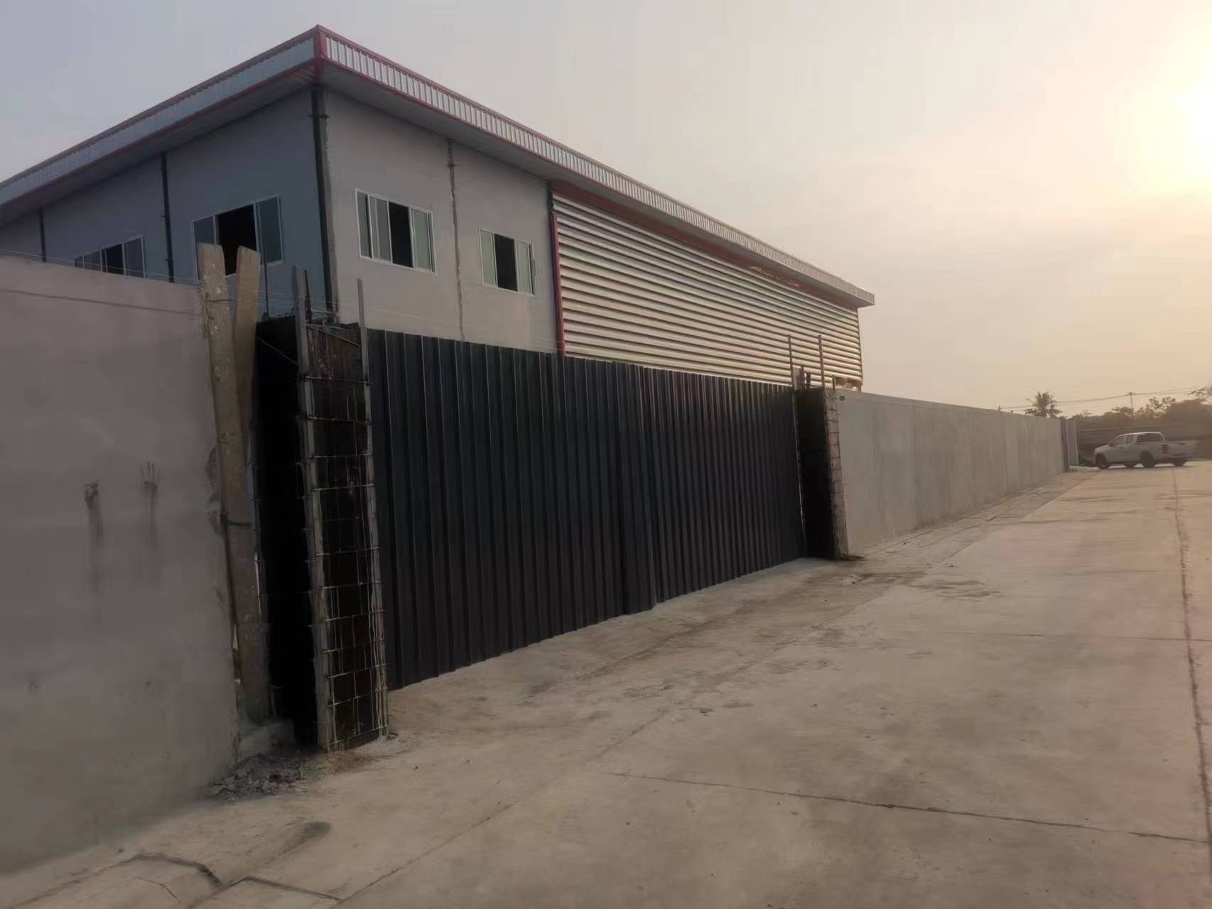 Exterior view of the Thailand steel structure workshop with corrugated wall cladding and paved site area