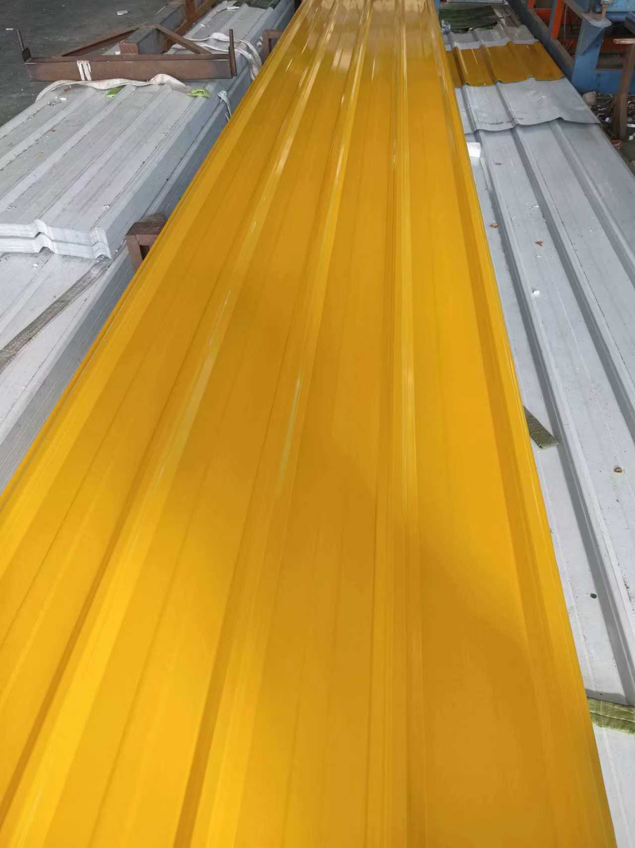 Close-up view of orange color-coated corrugated steel sheet used for building cladding